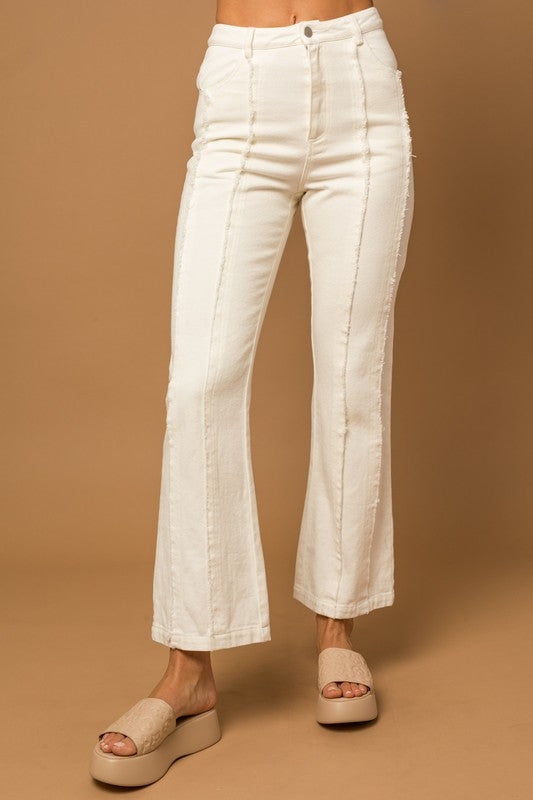 White cropped flare  pants with frayed lines going down